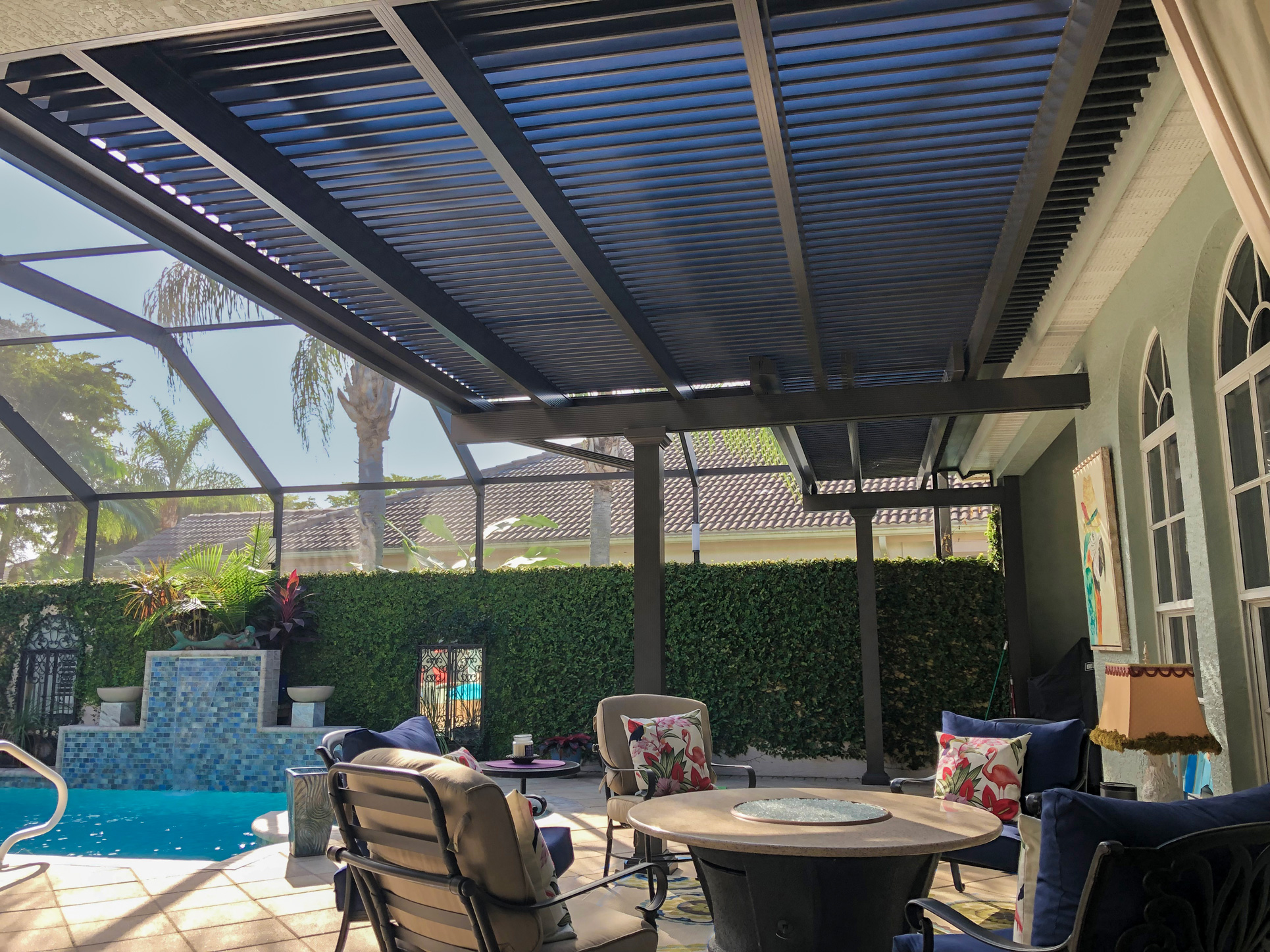 Operable aluminum pergola open above a furnished patio