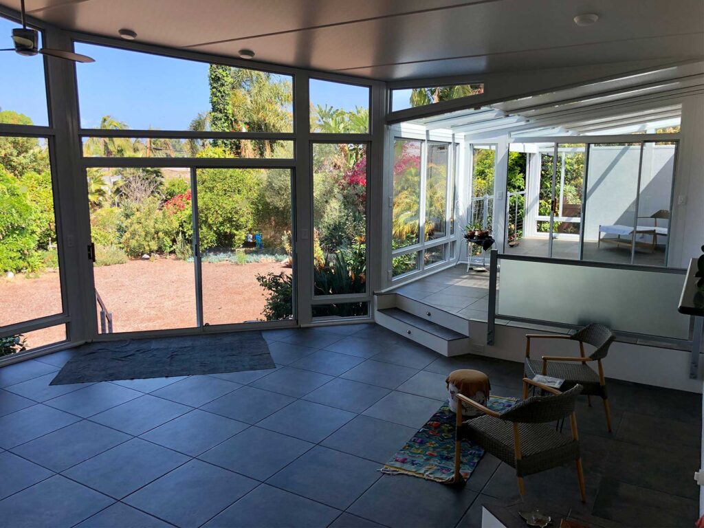 Bright sunroom interior with windows overlooking a landscaped yard